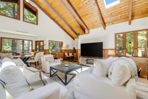 een woonkamer met witte meubels en een flatscreen-tv bij Surfwood Getaway in Mendocino