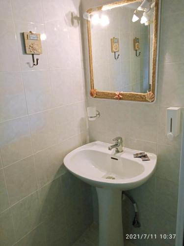 a bathroom with a sink and a mirror at Seashell apartment in Pefkohori
