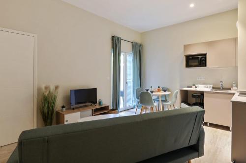 a living room with a couch and a kitchen at Appartement des Anges - Welkeys in Cannes