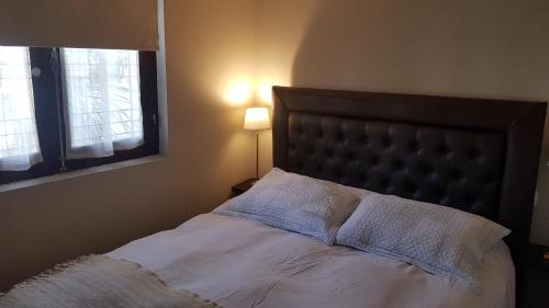 a bedroom with a bed with white sheets and a window at Las Rosas Apartamento in Cordoba