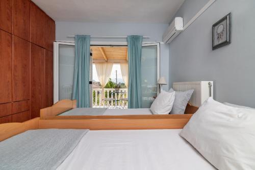 um quarto com 2 camas e uma grande janela em Villa Zakynthian treasure em Vanáton
