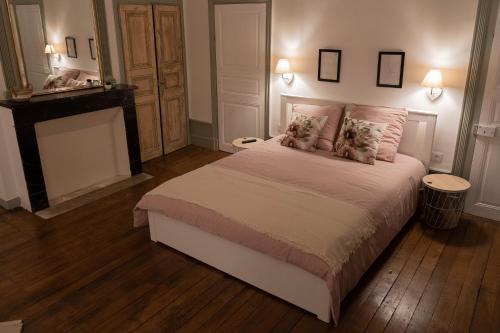 - une chambre avec un grand lit et une cheminée dans l'établissement un dimanche chez Julie chambre Léontine, à Parthenay