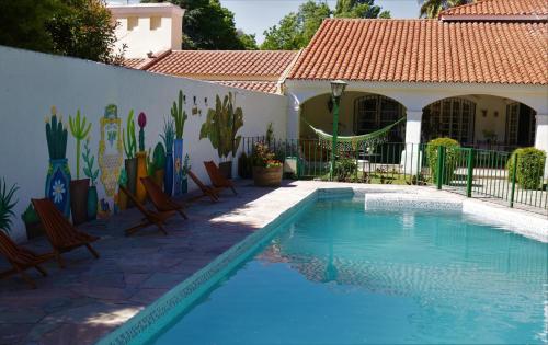 a swimming pool in front of a house at Chenin Lodge in Ciudad Lujan de Cuyo
