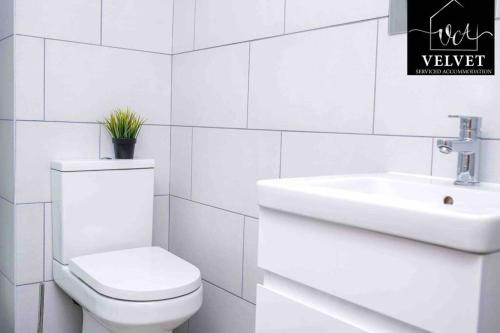 a white bathroom with a toilet and a sink at ✪ LEISURE/BUSINESS ✪ 1 Bedroom Apt , Free Parking in Swansea