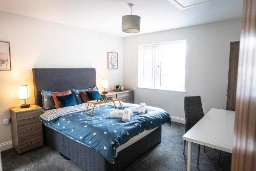a bedroom with a bed and a table and a window at ✪ LEISURE/BUSINESS ✪ 1 Bedroom Apt , Free Parking in Swansea