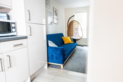 a blue couch in a kitchen with a microwave at ✪ LEISURE/BUSINESS ✪ 1 Bedroom Apt , Free Parking in Swansea