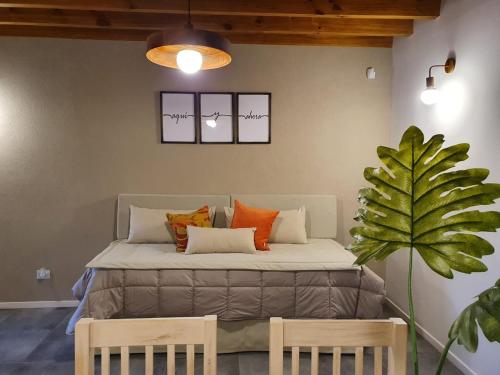 Una cama en una habitación con dos sillas y una planta. en Centinelas del Paraiso, en Villa La Angostura