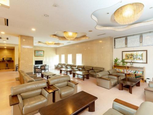 a waiting room at a hospital with couches and tables at Tabist Yabuki Station Hotel in Yabuki