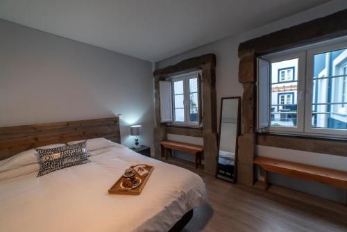 una camera da letto con un letto grande con un vassoio sopra di Sunrise - Casa Sao Joao - 4 Star Tourist Apartments ad Angra do Heroísmo