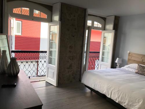 a bedroom with a bed and a balcony with red walls at Sunrise - Casa Sao Joao - 4 Star Tourist Apartments in Angra do Heroísmo