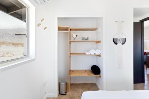 a bedroom with white walls and wooden shelves at Closest to Park Entrance, Stars, Private - WKNDR Starside in Twentynine Palms