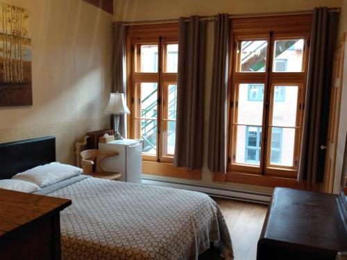 a bedroom with a bed and a large window at L'intendant in Quebec City