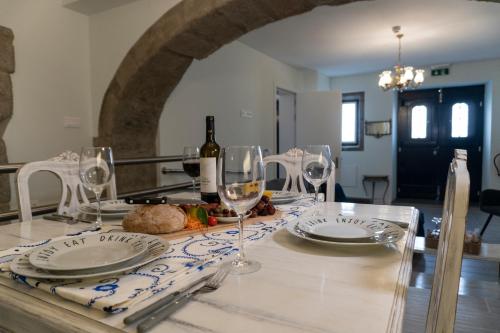 una mesa con copas y platos y una botella de vino en Ocean - Casa Sao Joao - 4 Star Tourist Apartments en Angra do Heroísmo