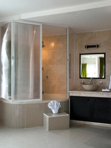 ein Badezimmer mit Waschbecken und Dusche mit Spiegel in der Unterkunft Kay Hotel in Playa del Carmen