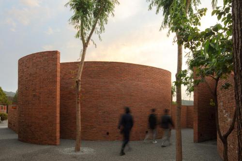 a brick wall with people walking past it at Brickyard Retreat at Mutianyu Great Wall Adjoin to Mutianyu Great Wall - Room with the View of Great Wall - Chinese massage experience - Vehicle Shuttle Service - International Catering - SPA& Nail Beauty Facilities in Huairou