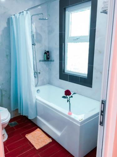 a bathroom with a white bath tub with a flower on it at Victory Airport Hotel in Ho Chi Minh City