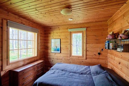 a bedroom with a bed in a wooden cabin at Viihtyisä lomamökki Levillä in Sirkka