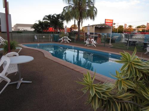 a swimming pool with people jumping in the water at Bundaberg East Cabin and Tourist Park in Bundaberg