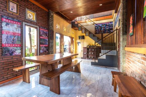 a restaurant with a wooden table and benches at The Garuda Villa and Restaurant in Bedugul