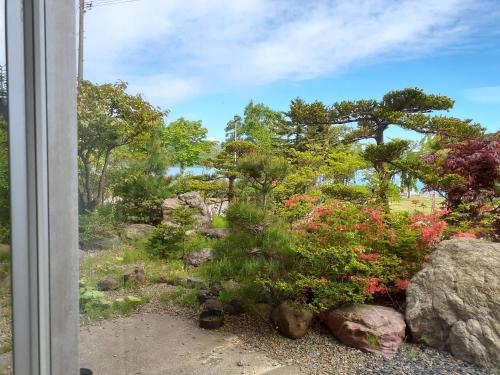 
a tree in front of a window in a garden at Hotel Grand Toya in Lake Toya
