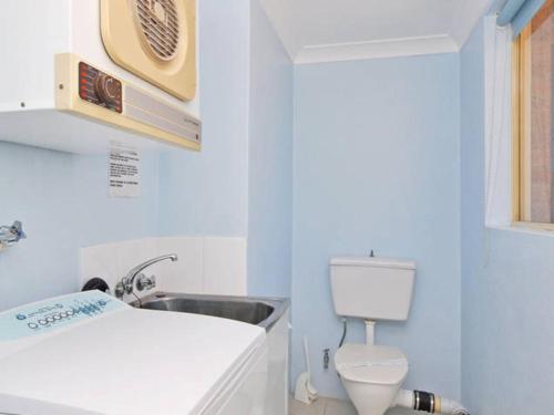 a bathroom with a white toilet and a sink at Toowoon Beach View 3br Villa 4 just steps to beach in The Entrance