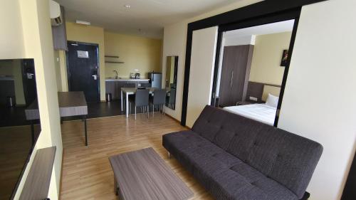 ein Wohnzimmer mit einem Sofa vor einem Spiegel in der Unterkunft Hotel MetraSquare in Malakka