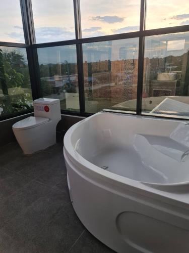 a large bathroom with a tub and a window at 88 ลิฟวิ่ง โฮเทล ปากช่อง in Ban Sathani Bandai Ma