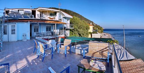 een balkon van een huis met stoelen en de oceaan bij Rena's Rooms Μελίντα in Melínta