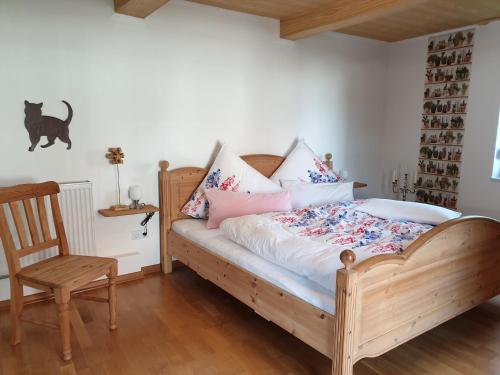 1 dormitorio con cama de madera y silla de madera en Ferienwohnung zur Töpferstube en Spabrücken