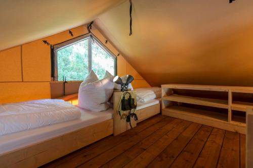 a bedroom with two beds and a window at Ferienpark Terrassencamping Süd-See in Walchsee