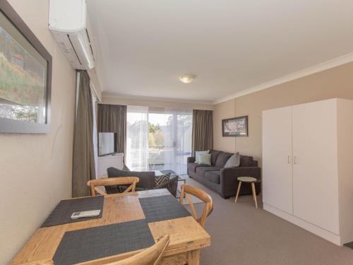 a living room with a table and a couch at Horizons 501 in Jindabyne