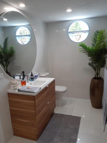 ein Bad mit einem Waschbecken und einem Spiegel in der Unterkunft SeaTurtle in Clifton Beach
