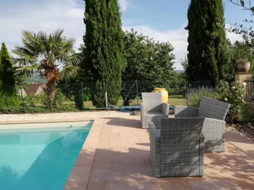 um grupo de cadeiras ao lado de uma piscina em La Maison de Joindy em Saint-Cyprien