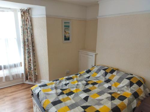 a bedroom with a couch with a checkered blanket at 52 Cambrian St in Aberystwyth