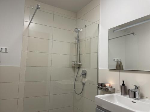 biała łazienka z prysznicem i umywalką w obiekcie Grimmingblick Apartment 206 by AA Holiday Homes w mieście Tauplitz