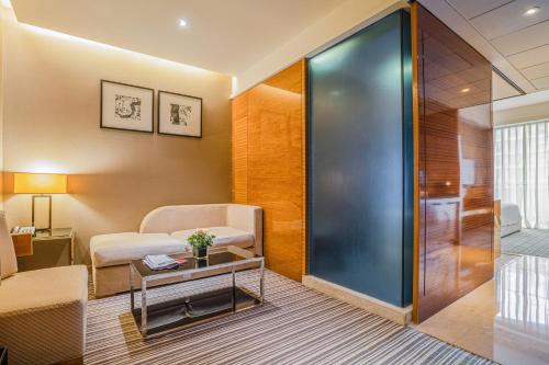 a room with a couch and a table and a glass door at Pullman Foshan Shunde-Canton Fair Shuttle Bus at Extra RMB100 per Person Daily in Shunde