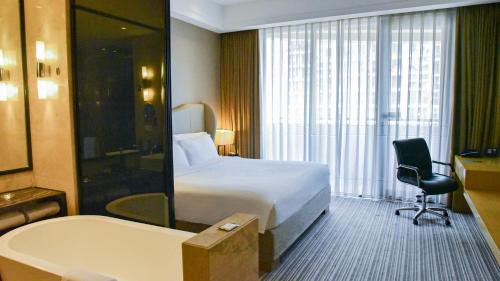 a hotel room with a bed and a bath tub at Pullman Foshan Shunde-Canton Fair Shuttle Bus at Extra RMB100 per Person Daily in Shunde