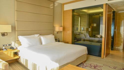 a bedroom with a large bed and a bathroom at Pullman Foshan Shunde-Canton Fair Shuttle Bus at Extra RMB100 per Person Daily in Shunde