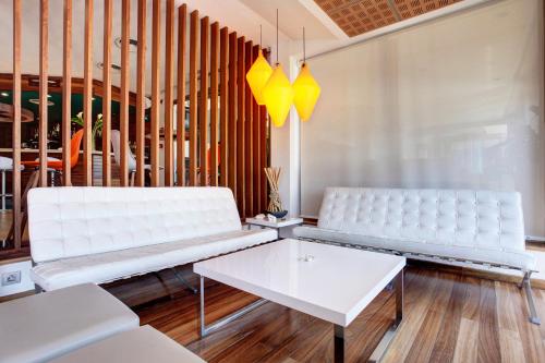 a living room with two white benches and a table at Hotel Costa Azul in Palma de Mallorca