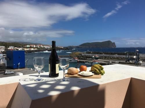 a table with a bottle of wine and two glasses at Ocean Front Home - Casa Santo Antonio in São Mateus