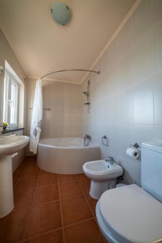 a bathroom with a tub and a toilet and a sink at Ocean Front Home - Casa Santo Antonio in São Mateus