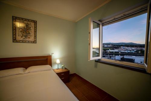 1 dormitorio con cama y ventana con vistas en Ocean Front Home - Casa Santo Antonio, en São Mateus