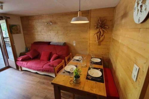 un salon avec un canapé rouge et une table dans l'établissement Appartement l'Edel - Vue Massif Mont-Blanc, à Saint-Gervais-les-Bains