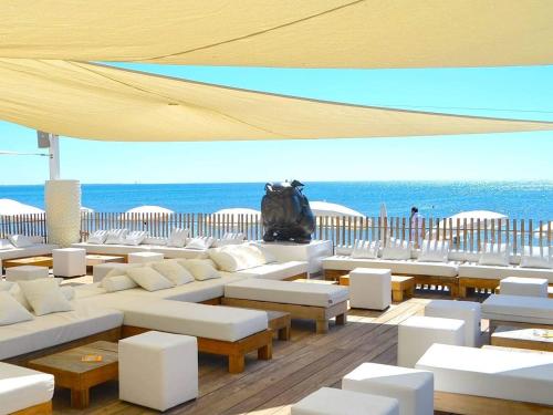モンペリエにあるAppart - Suites Gaya Centre Villeの海を望むパティオ(白いソファ、テーブル付)