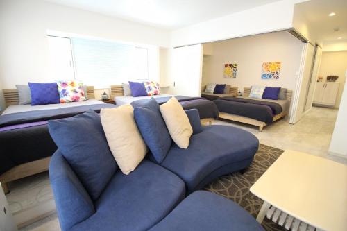 a living room with a blue couch with pillows at Condominium Felicita Naha in Naha