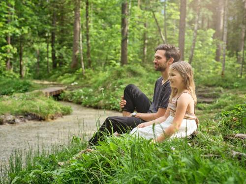 a man and a woman sitting in the woods at Luxury Chalets Gradenbach near Schladming in Haus im Ennstal
