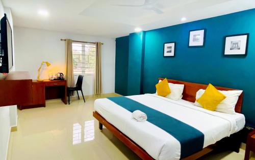 a bedroom with a large bed with a blue wall at The Reach Hotel in Cochin