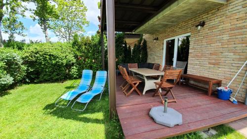 a deck with chairs and a table and a table and chairs at Wellapartman in Zamárdi