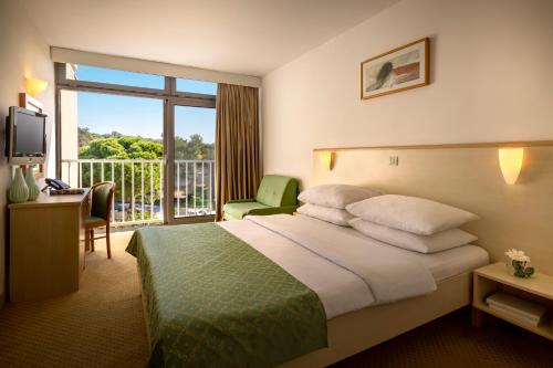 波雷奇的住宿－Rubin Sunny Hotel，酒店客房设有一张床和一个阳台。