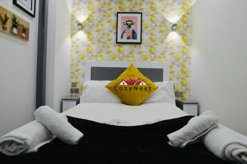 a bedroom with a bed with a yellow pillow on it at Classy Central Self Contained Flat by CozyNest in Reading